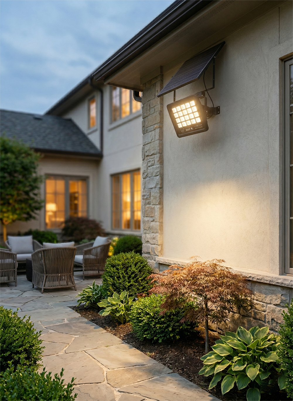 Wall-mounted solar security light with adjustable panel, illuminating a private stone patio and villa backyard.