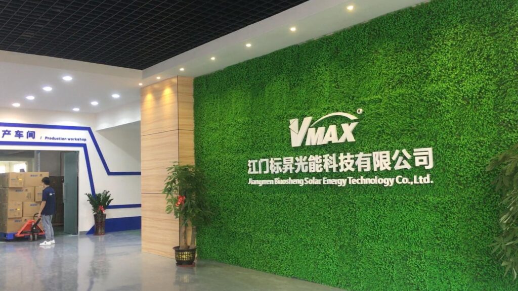 Reception area of Jiangmen Biaosheng Solar Energy Technology, showing the green logo wall and entrance to the production workshop.