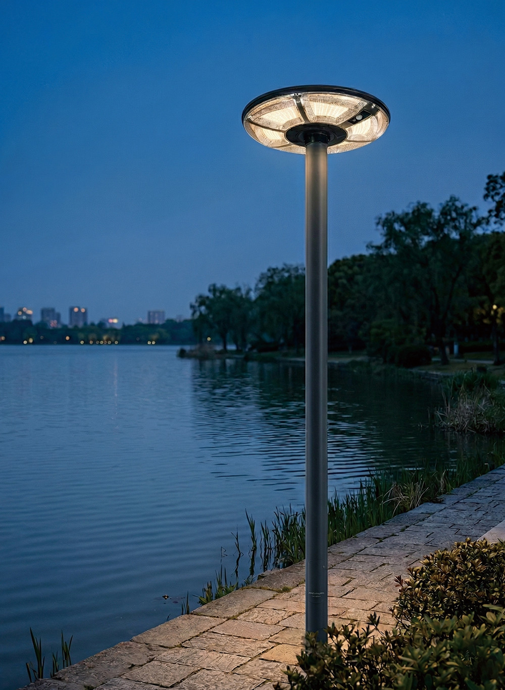 Commercial UFO solar post top light (Model MD-SLT39) providing 360-degree illumination for a lakeside park pathway.